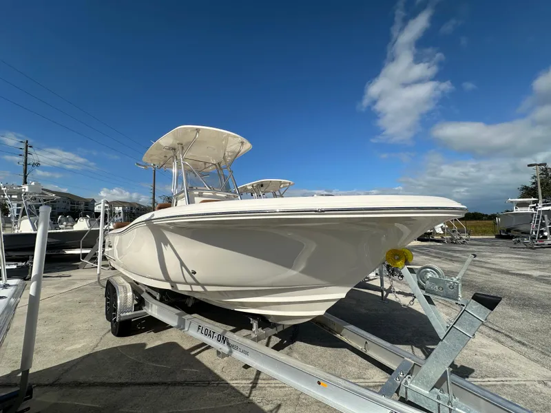 Slide: The Image of 2025 Pioneer 222 Sportfish boat on trailer under clear blue sky. - 2