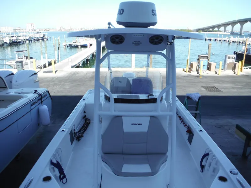 Slide: The Image of 2018 Sea Pro 248 Bay boat docked at marina with clear blue water. - 12