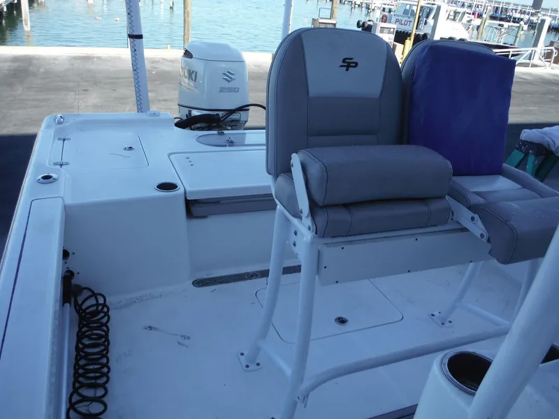 Slide: The Image of 2018 Sea Pro 248 Bay boat interior with seating and motor, docked by the water. - 13