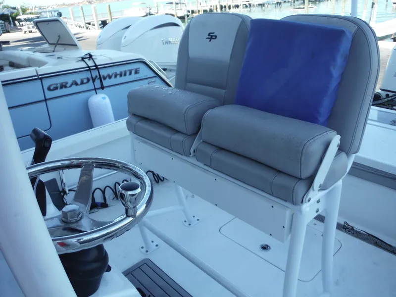 Slide: The Image of 2018 Sea Pro 248 Bay boat interior with steering wheel and cushioned seats. - 23