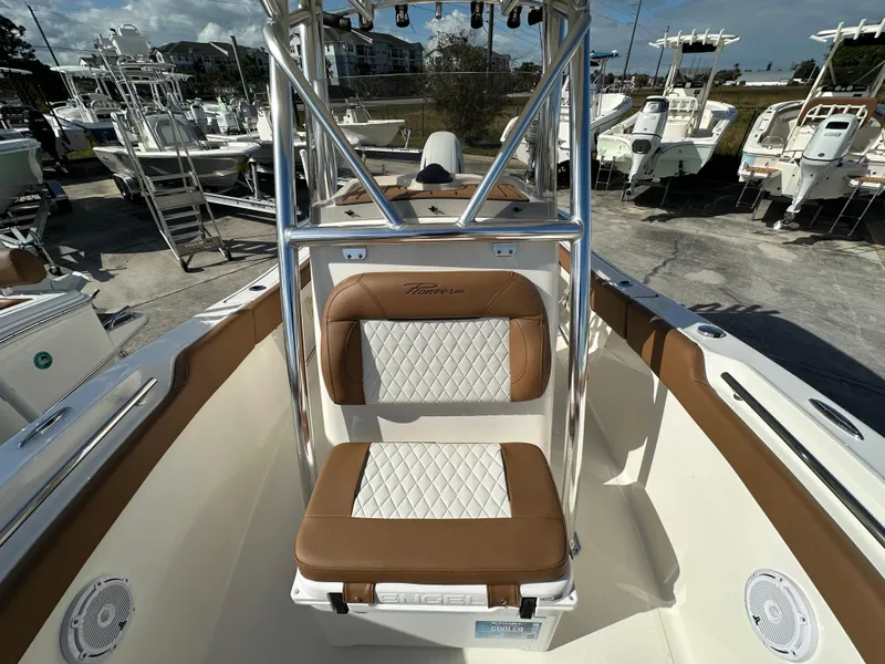 Slide: The Image of 2025 Pioneer 202 Sportfish boat with tan and white seating, docked outdoors. - 7