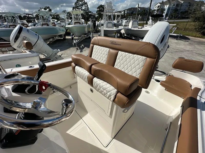Slide: The Image of 2025 Pioneer 202 Sportfish boat interior with brown and white seating, steering wheel, and controls. - 9