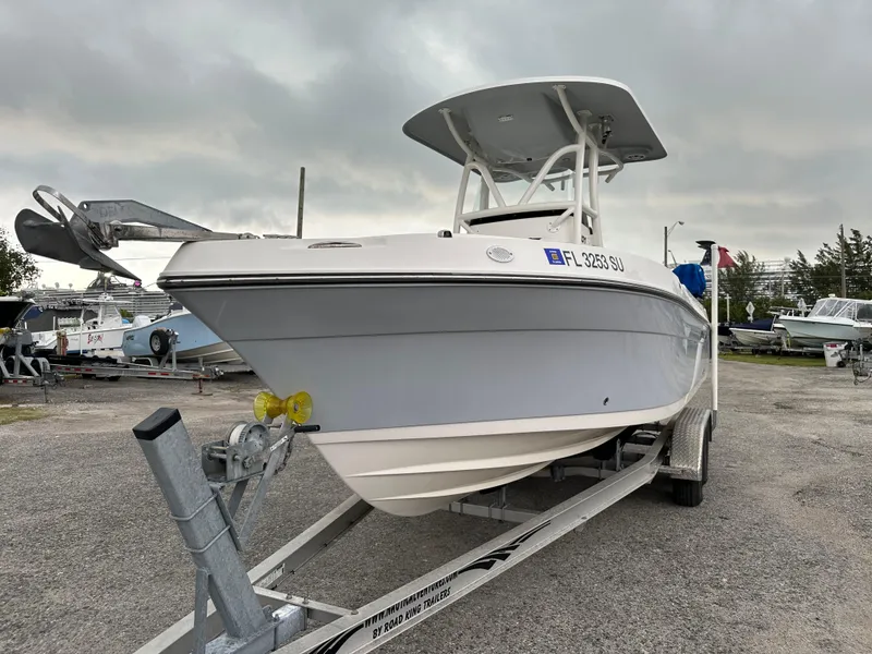 Slide: The Image of 2015 Century 2301 boat on trailer, parked outdoors under cloudy sky. - 11