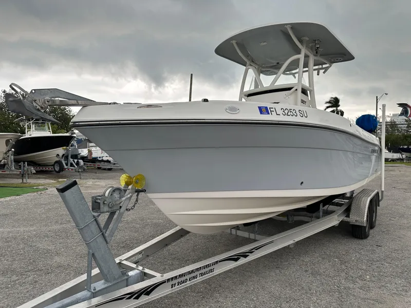 Slide: The Image of 2015 Century 2301 boat on trailer, parked outdoors under cloudy sky. - 12