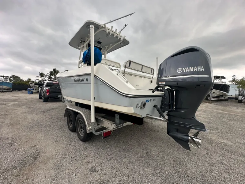 Slide: The Image of Century 2301 boat with Yamaha engine on trailer, parked outdoors, cloudy sky. - 15