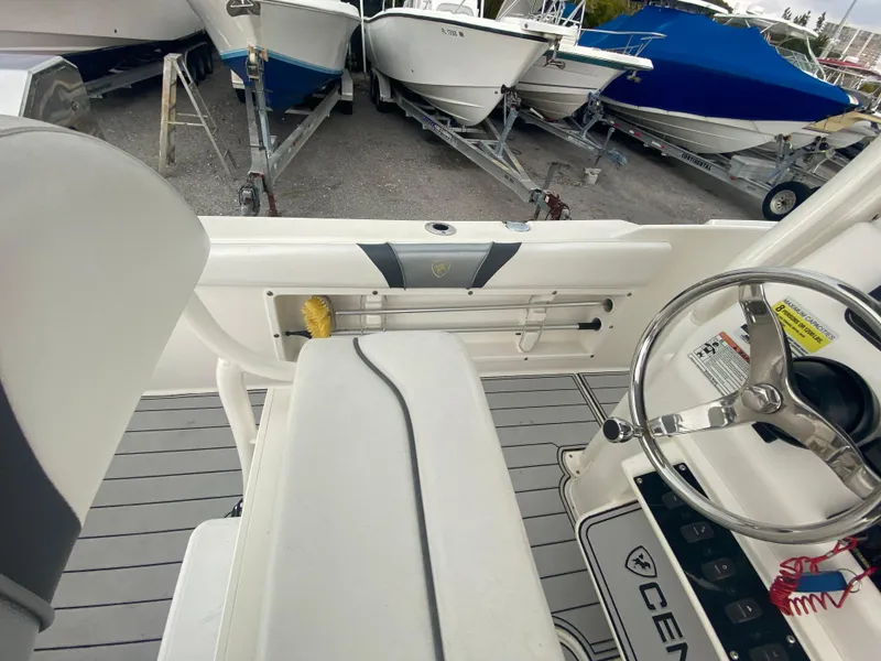 Slide: The Image of Interior view of a 2015 Century 2301 boat, showcasing steering wheel and seating area. - 28