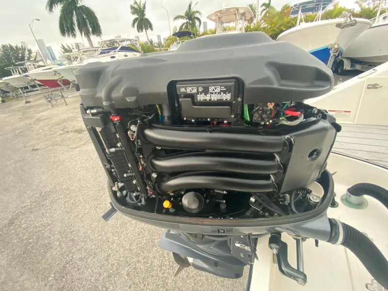 Slide: The Image of 2015 Century 2301 boat engine, detailed view, with surrounding boats and palm trees. - 35