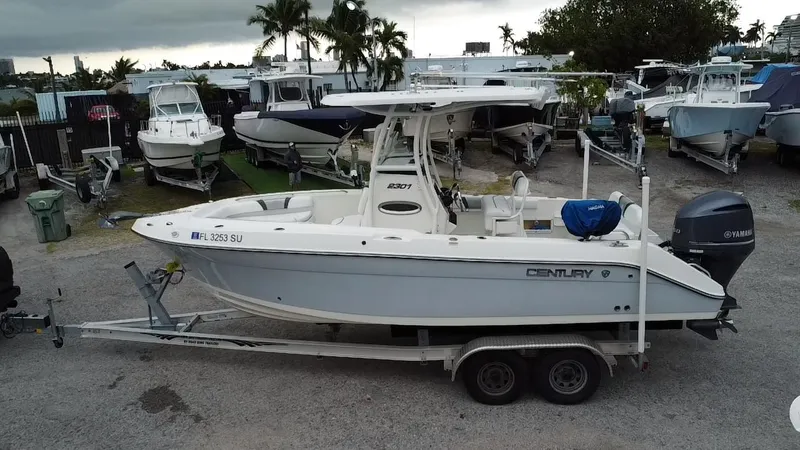 Slide: The Image of 2015 Century 2301 boat on trailer, parked in marina with other boats. - 4
