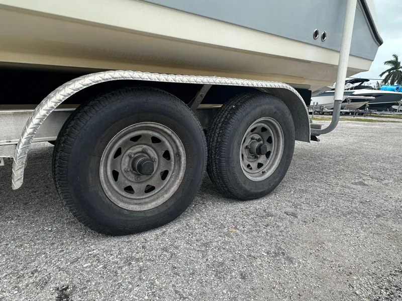 Slide: The Image of Trailer wheels of a 2015 Century 2301 boat on pavement. - 40