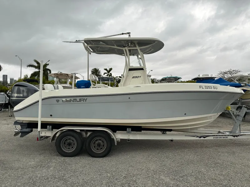 Slide: The Image of 2015 Century 2301 boat on trailer, parked outdoors under cloudy sky. - 9