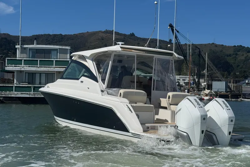 Slide: The Image of 2026 Tiara Yachts 34 LX cruising in a marina with dual outboard engines. - 2