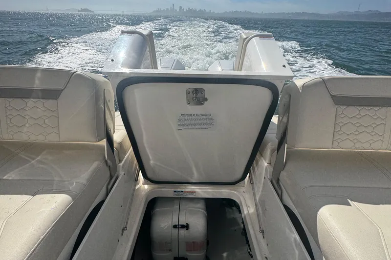 Slide: The Image of 2026 Tiara Yachts 34 LX cruising on open water, showcasing luxurious seating and engine compartment. - 62