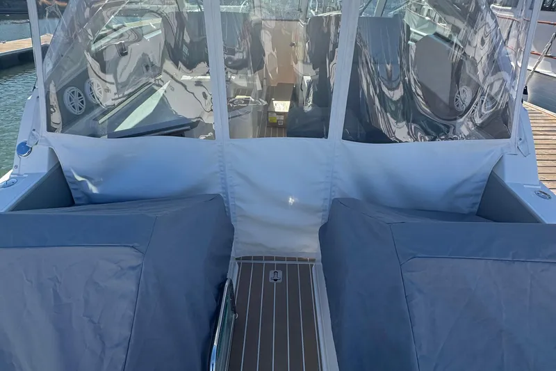Slide: The Image of 2026 Tiara Yachts 34 LX with covered seating and clear canopy at dock. - 63