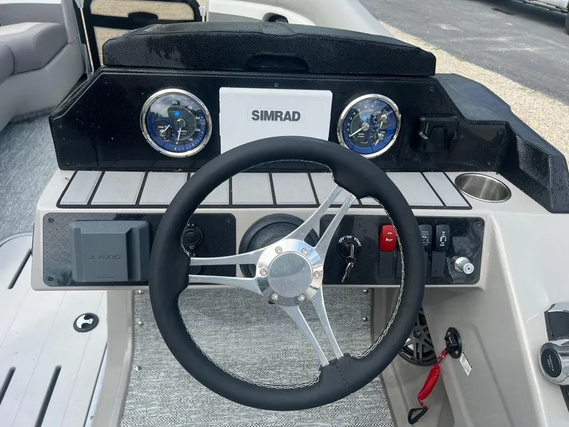 Slide: The Image of 2024 Premier 230 SunSation RF boat dashboard with steering wheel and Simrad display. - 2