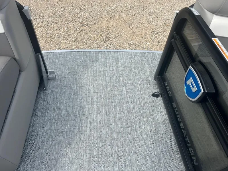 Slide: The Image of 2024 Premier 230 SunSation RF boat interior with gray flooring and open door. - 5