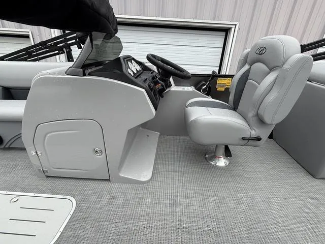 Slide: The Image of 2025 Bentley Pontoons Legacy 243 Navigator interior with gray captain's chair and console. - 12