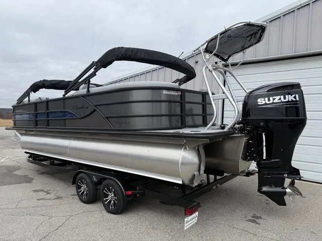 Slide: The Image of 2025 Bentley Pontoons Legacy 243 Navigator with Suzuki outboard motor on trailer. - 2