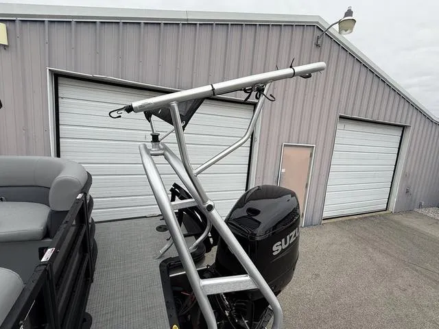 Slide: The Image of 2025 Bentley Pontoons Legacy 243 Navigator with Suzuki engine near garage. - 21