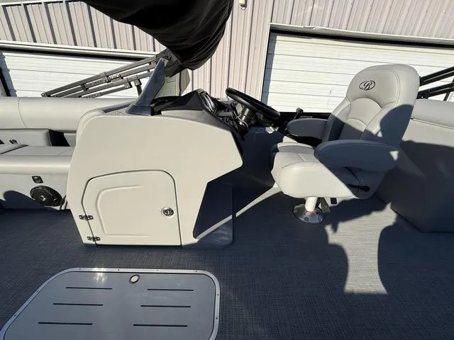 Slide: The Image of 2025 Bentley Pontoons Legacy 223 Navigator interior with steering console and captain's chair. - 14