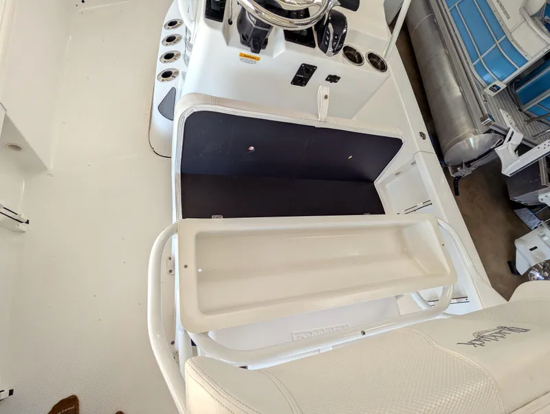 Slide: The Image of 2025 BlackJack 224 boat interior with open storage compartment and steering console. - 11