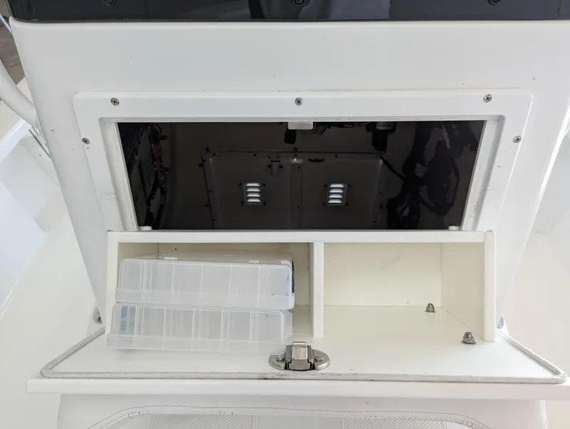 Slide: The Image of Boat storage compartment with clear plastic containers, BlackJack 224, 2025 model. - 14
