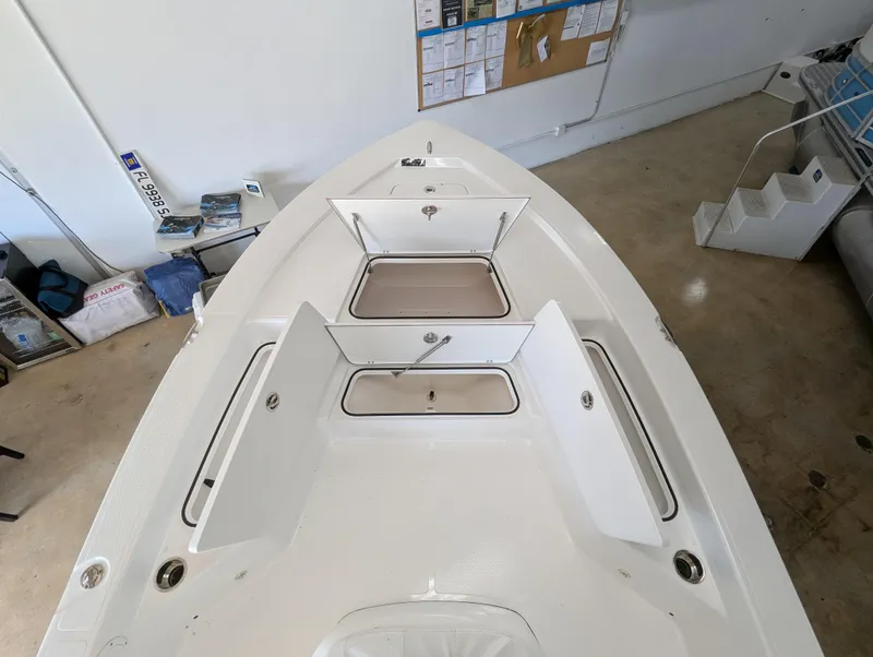 Slide: The Image of 2025 BlackJack 224 boat interior with open storage compartments in a showroom. - 16