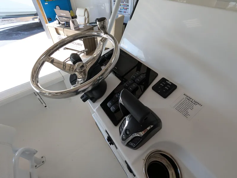 Slide: The Image of Steering console of 2025 BlackJack 224 boat with modern controls and chrome wheel. - 9