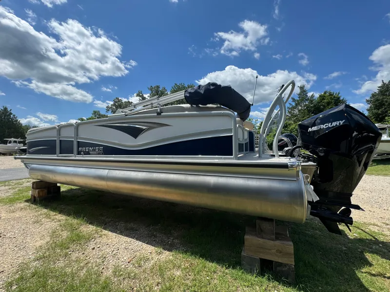 Slide: The Image of 2023 Premier 250 Solaris RF pontoon boat with Mercury engine on display outdoors. - 1