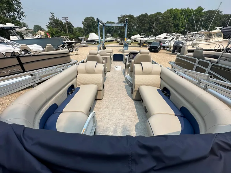 Slide: The Image of 2023 Premier 250 Solaris RF pontoon boat with spacious seating at a marina. - 6