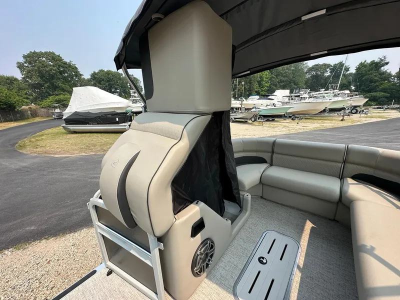 Slide: The Image of 2023 Premier 250 Solaris RL boat interior with seating and storage, docked outdoors. - 15