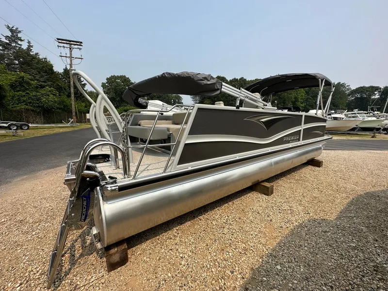 Slide: The Image of 2023 Premier 250 Solaris RL pontoon boat on gravel lot, side view. - 2