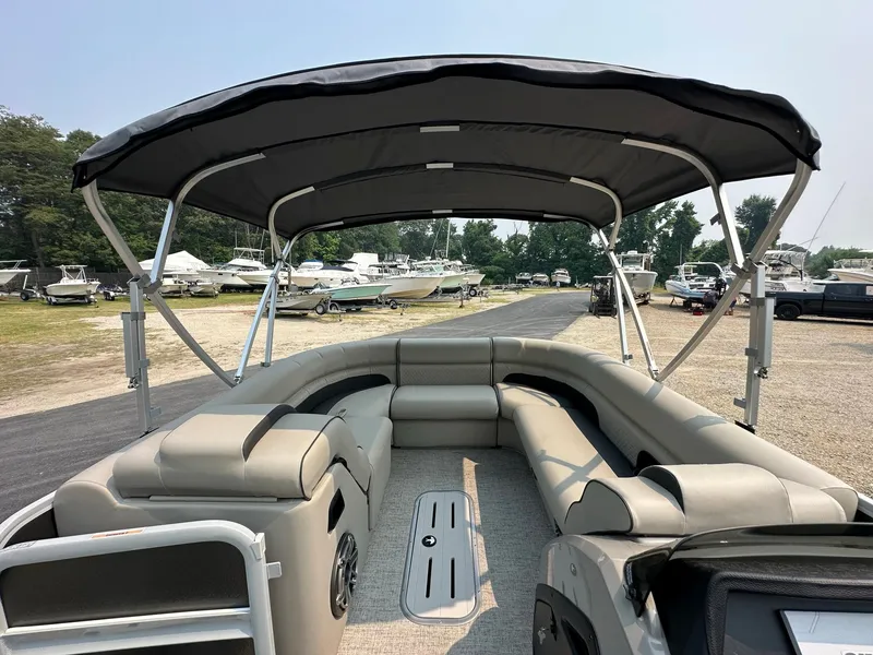 Slide: The Image of 2023 Premier 250 Solaris RL pontoon boat with spacious seating and canopy, docked outdoors. - 7