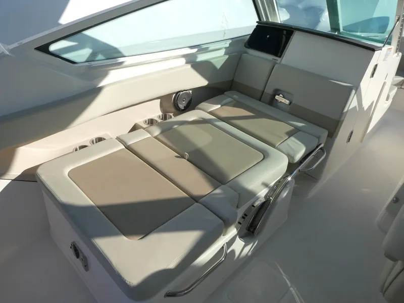 Slide: The Image of 2025 Boston Whaler 280 Vantage interior seating area with beige cushions. - 4
