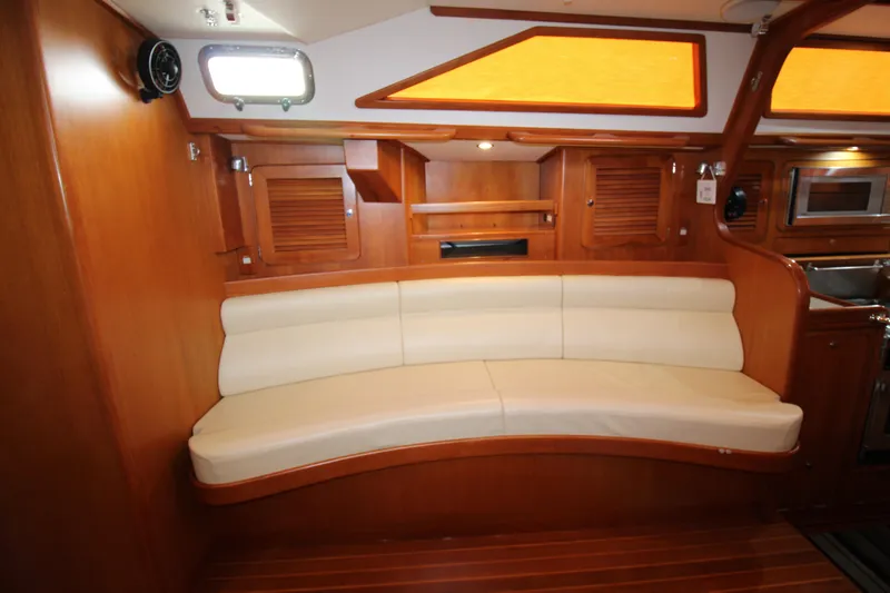 Slide: The Image of Interior of 2006 Hylas 49 Center Cockpit with curved seating and wooden cabinetry. - 14