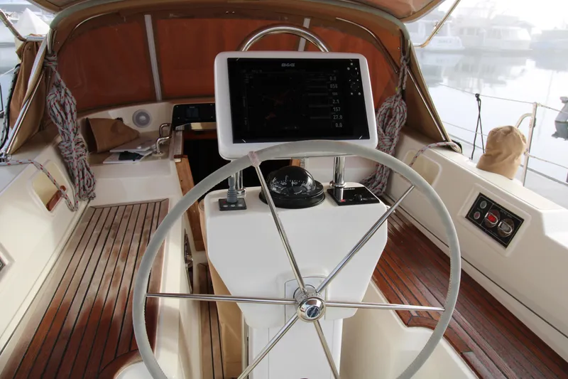 Slide: The Image of 2006 Hylas 49 Center Cockpit with steering wheel and navigation display in a wooden interior. - 23