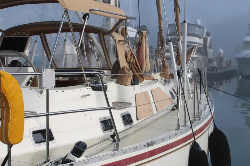 Slide: The Image of 2006 Hylas 49 Center Cockpit sailboat docked in a marina, featuring beige canvas covers. - 4