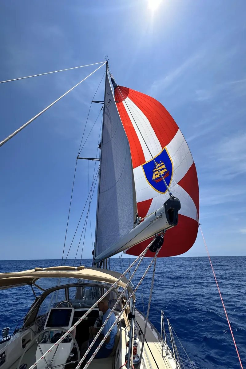 Slide: The Image of Sailing on a 2006 Hylas 49 Center Cockpit with vibrant spinnaker under clear blue skies. - 6