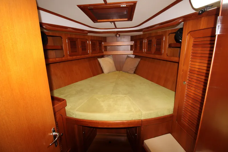 Slide: The Image of 2006 Hylas 49 Center Cockpit interior with wooden finish and cozy sleeping area. - 9