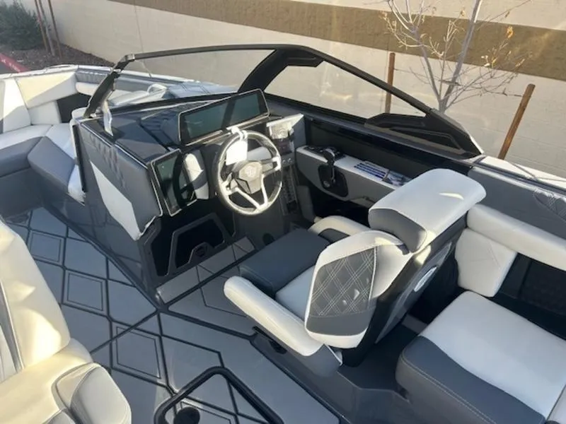 Slide: The Image of 2025 Malibu M230 boat interior with modern dashboard and seating. - 13