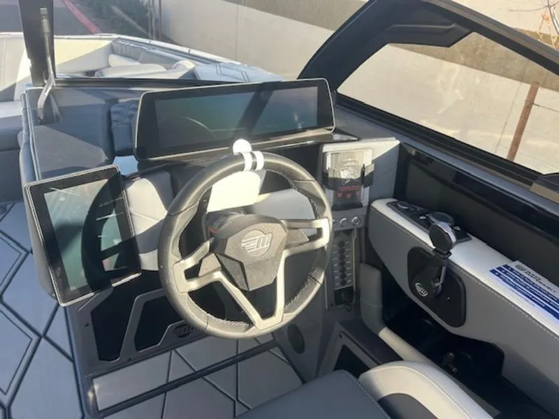 Slide: The Image of 2025 Malibu M230 boat dashboard with modern steering wheel and digital displays. - 14