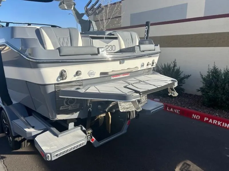 Slide: The Image of 2025 Malibu M230 boat rear view with swim platform in parking area. - 4