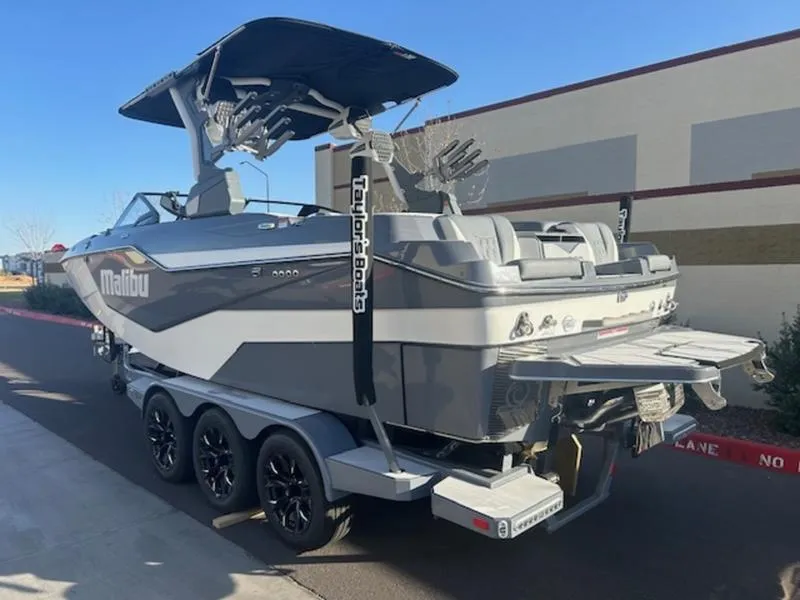 Slide: The Image of 2025 Malibu M230 boat on trailer, sleek design, parked outdoors. - 5