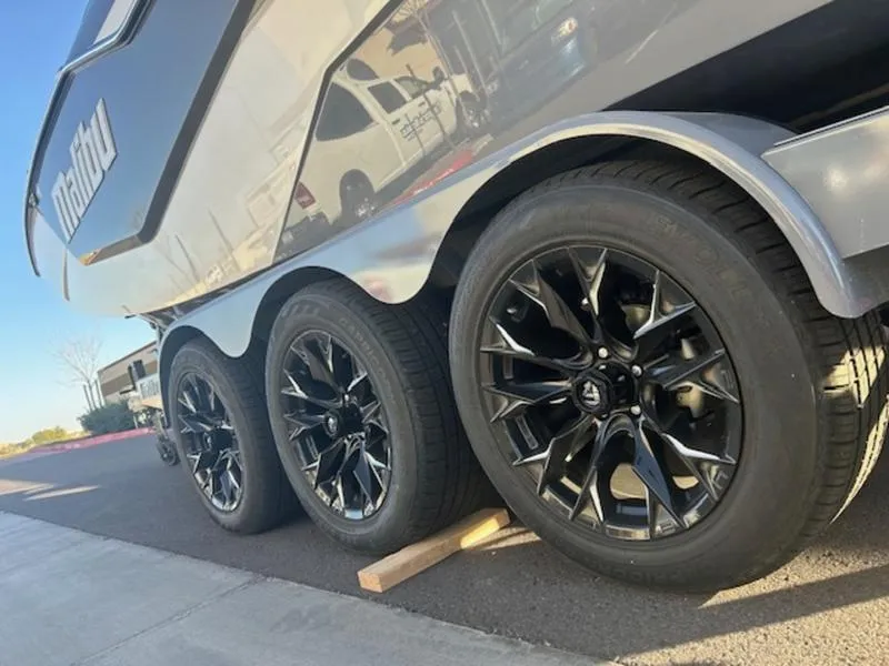 Slide: The Image of 2025 Malibu M230 boat trailer with sleek black wheels on pavement. - 7