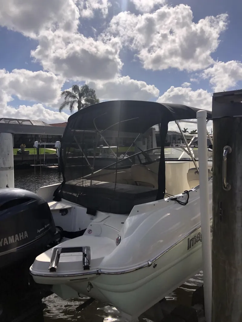Slide: The Image of 2021 Stingray 214 LR boat docked under a cloudy sky. - 11