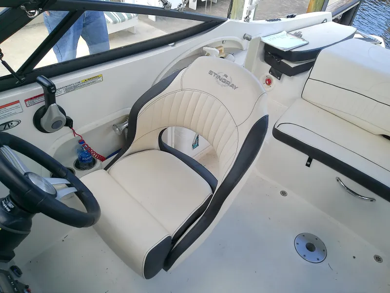 Slide: The Image of 2021 Stingray 214 LR boat interior with beige seating and steering wheel. - 30