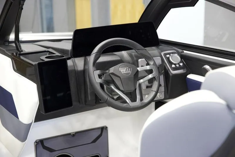 Slide: The Image of 2025 Malibu 23 LSV boat dashboard with modern steering wheel and digital controls. - 13