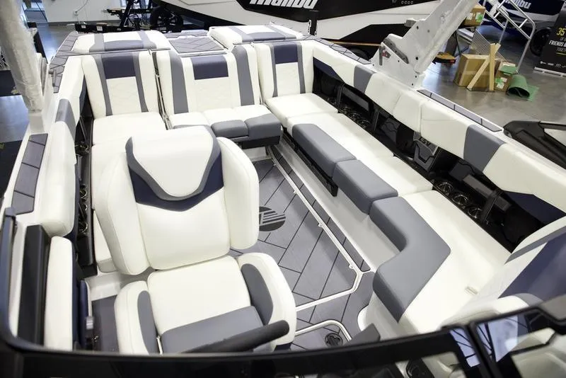 Slide: The Image of 2025 Malibu 23 LSV boat interior with modern white and gray seating design. - 24