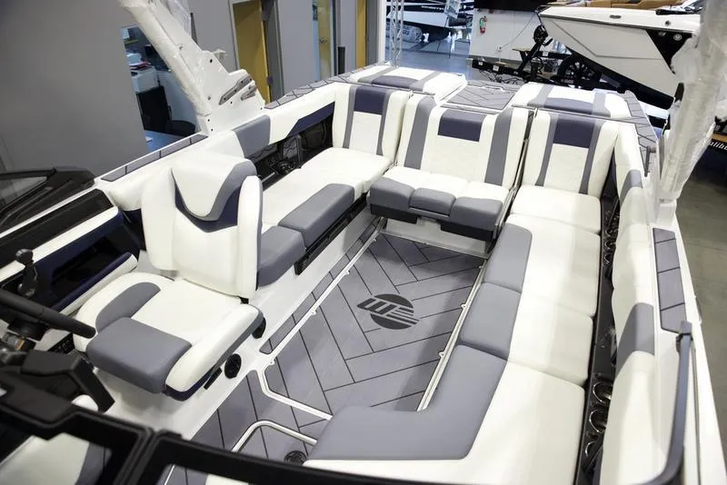 Slide: The Image of 2025 Malibu 23 LSV boat interior with luxurious white and gray seating. - 25