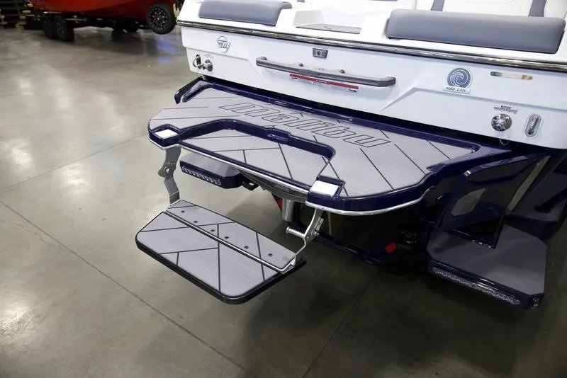 Slide: The Image of 2025 Malibu 23 LSV boat with swim platform and step ladder in showroom. - 6