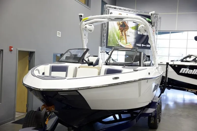 Slide: The Image of 2025 Malibu 23 LSV boat displayed indoors on a trailer. - 9